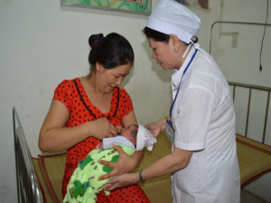 Trưởng Trạm Y tế phường An Lạc Liên Kim Em đang hướng dẫn bà mẹ cho con bú đúng cách