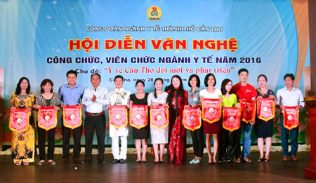 DS.CKII Nguyễn Phước Tồn, Phó Giám đốc Sở Y tế và bà Trương Thị Minh Thu, Chủ tịch Công đoàn ngành Y tế, trao cờ lưu niệm cho các đội tham gia Hội diễn văn nghệ.