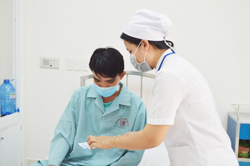 Cán bộ y tế Bệnh viện Lao và Bệnh phổi TP Cần Thơ hướng dẫn cách sử dụng thuốc cho bệnh nhân khám chữa bệnh bảo hiểm y tế tại bệnh viện. Ảnh: Thúy Duy