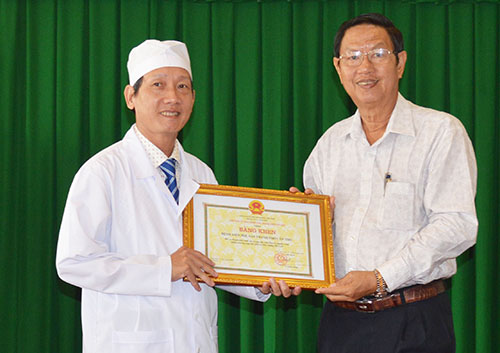 Ông Lê Văn Tâm, Phó Chủ tịch thường trực UBND thành phố trao bằng khen cho giám đốc bệnh viện.