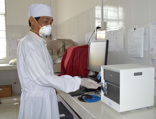 Cán bộ y tế đang xét nghiệm mẫu đàm trên máy Gene Xpert tại Trung tâm Y tế quận Thốt Nốt.