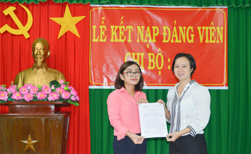 Đồng chí Trần Phương Hà, Bí thư Chi bộ 4 công bố và trao Quyết định kết nạp đảng cho đồng chí Trần Ngọc Lan Chi.