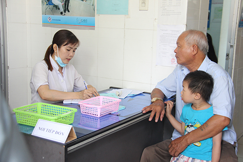 Gia đình đưa trẻ đến tiêm trong Chiến dịch tiêm bổ sung vắc xin sởi – rubella tại trạm Y tế phường An Hòa