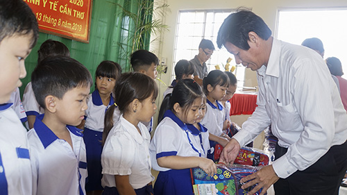 BS.CKII Cao Minh Chu, Phó Giám đốc Sở Y tế trao quà cho các em học sinh.