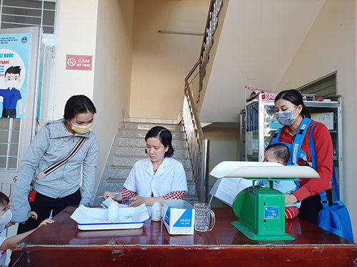 Cán bộ y tế Trạm Y tế phường Thới Bình hướng dẫn bà mẹ đưa trẻ đến uống vitamin A đợt 1 tại trạm