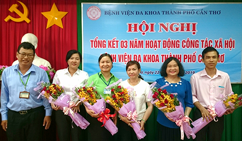 Ông Lâm Hữu Đức, Trưởng phòng Quản lý chất lượng Bệnh viện Đa khoa thành phố tặng hoa và chụp hình lưu niệm cùng các đại biểu tại Hội nghị.