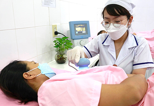 Nhân viên y tế sử dụng máy siêu âm đa tần điều trị tắc tia sữa cho sản phụ
