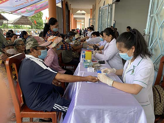 Người dân được các cán bộ y tế thử đường huyết, tư vấn chăm sóc sức khỏe.